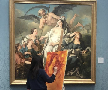A woman painting a copy of an old master painting in a gallery.