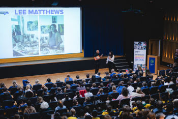 Children in an auditorium with Lee giving a presentation on her work